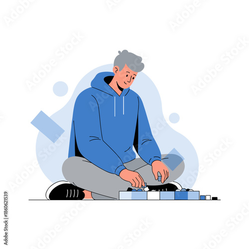 Young caucasian male building with blocks in blue hoodie