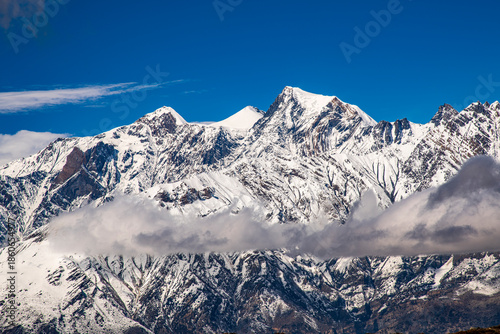 Canvas Print Snow-covered Nilgiri mountains under moving clouds near Muktinath, Nepal