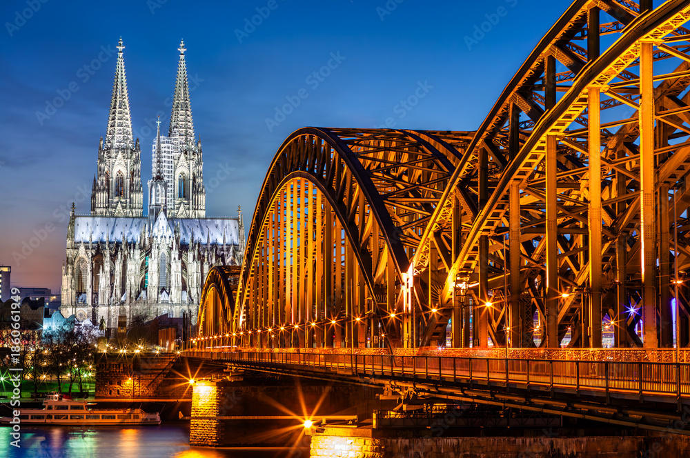 Obraz premium Hohenzollern Bridge and Cologne Cathedral at dusk, in Koln, Germany.