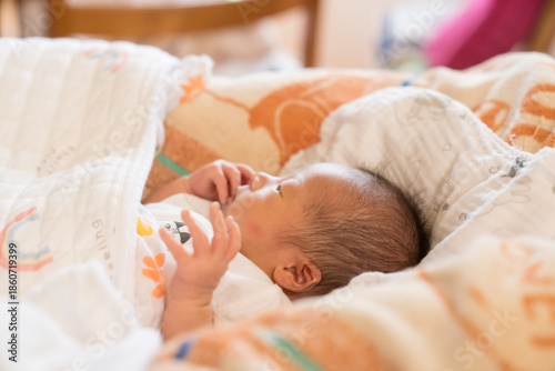 ベビーベッドで眠る日本人の男の子の乳児