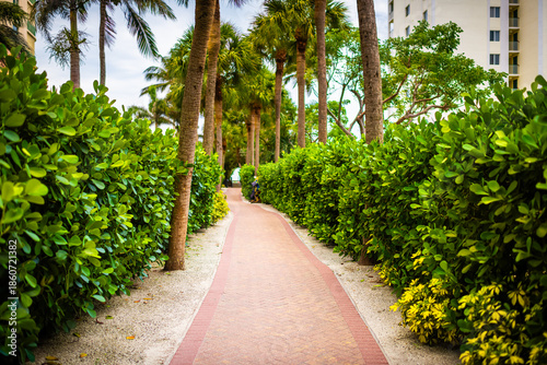 Marco Island of Southwest Florida path paved boardwalk to beach access by condo apartment waterfront building in summer