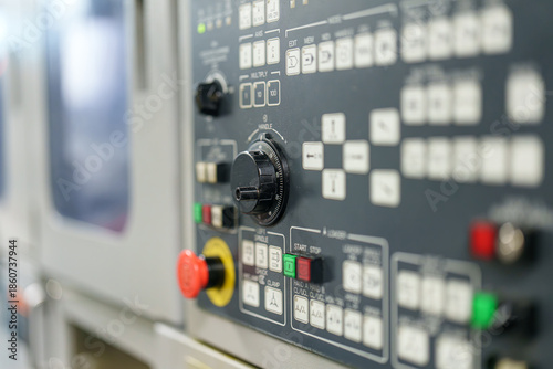 Control panel shows buttons and knobs used for machine operation in a factory setting during working hours