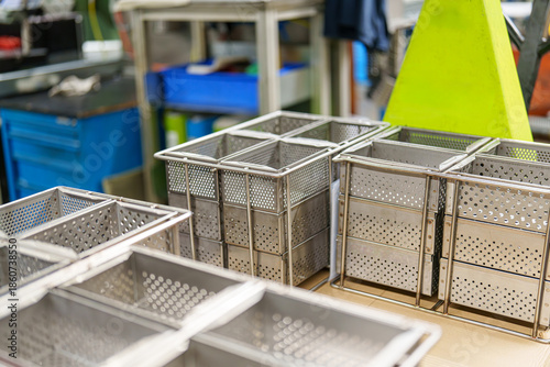 Fotografi Storage baskets are arranged on a worktable in a busy workshop during the day in