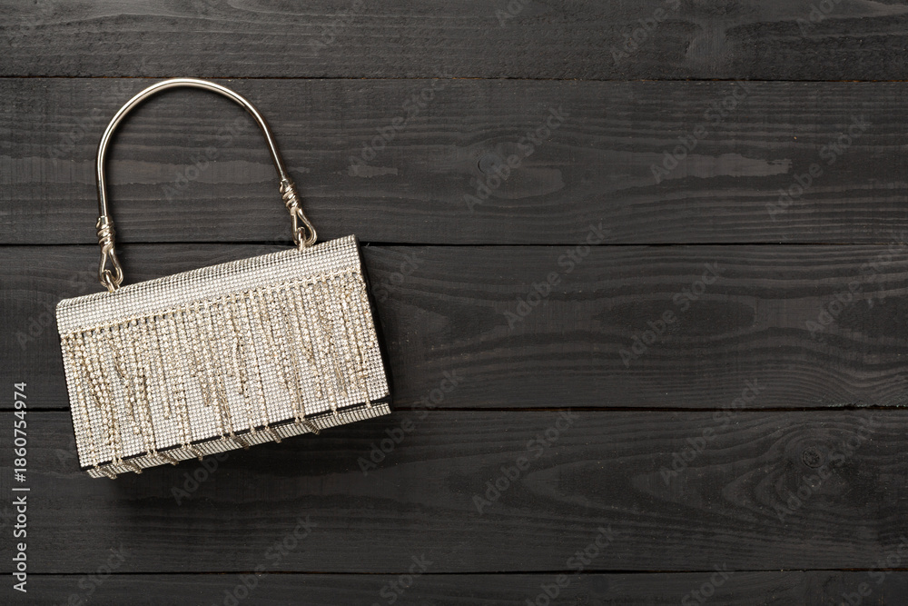 Fototapeta premium Handbag with beads on wooden background, top view