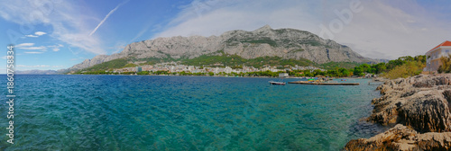 Panoramic view of the turquoise water of the Adriatic Sea and the town of Makarska, Croatia, with the Biokovo mountain in sunny summer day