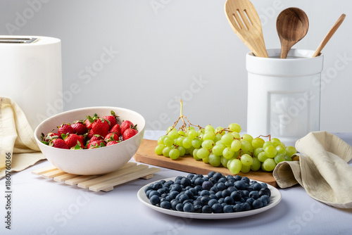 Cuadro en lienzo Containers with strawberries, blueberries, and green grapes.