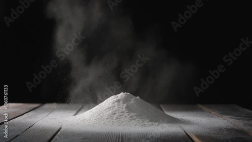 A pristine white powder mound sits on a rustic wooden table with a smoky dark background.