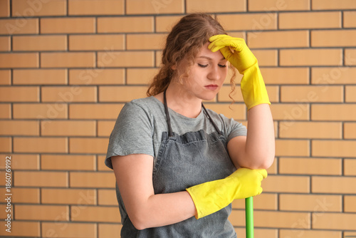 Tired female janitor with m...