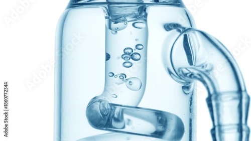 Massive macro view of pale blue liquid flowing through a glass tube, causing bubbles to condense and chaotically move inside it on pure white