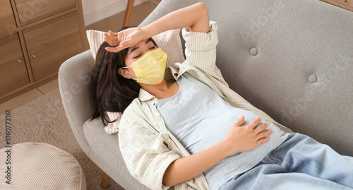 Pregnant Asian woman in yel...