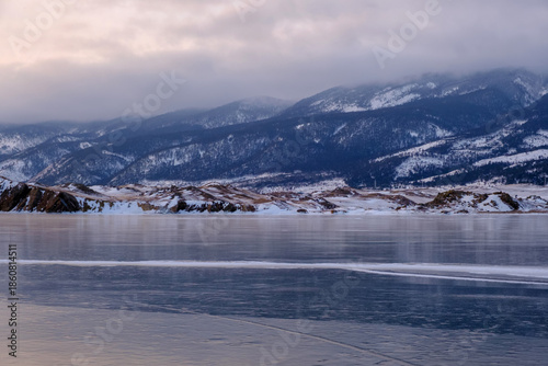 Baikal Lake in winter. Beautiful landscape with mountains reflected in ice of frozen Small Sea