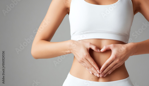 Wallpaper Mural A woman's hands forming a heart shape on her bare midriff with smooth skin and a white sleeveless top Torontodigital.ca