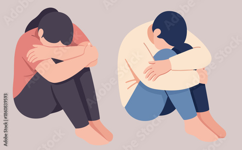 Two people are sitting curled up with their heads down, appearing sad or distressed.