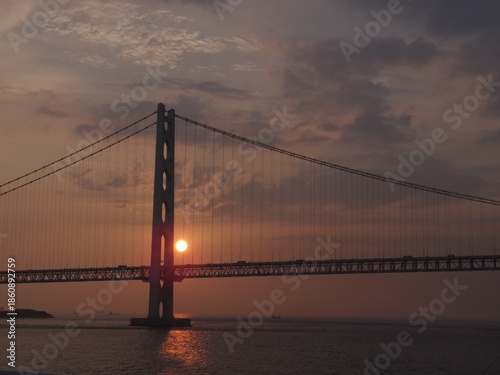 夕日に照らされた大きな吊り橋と海の風景