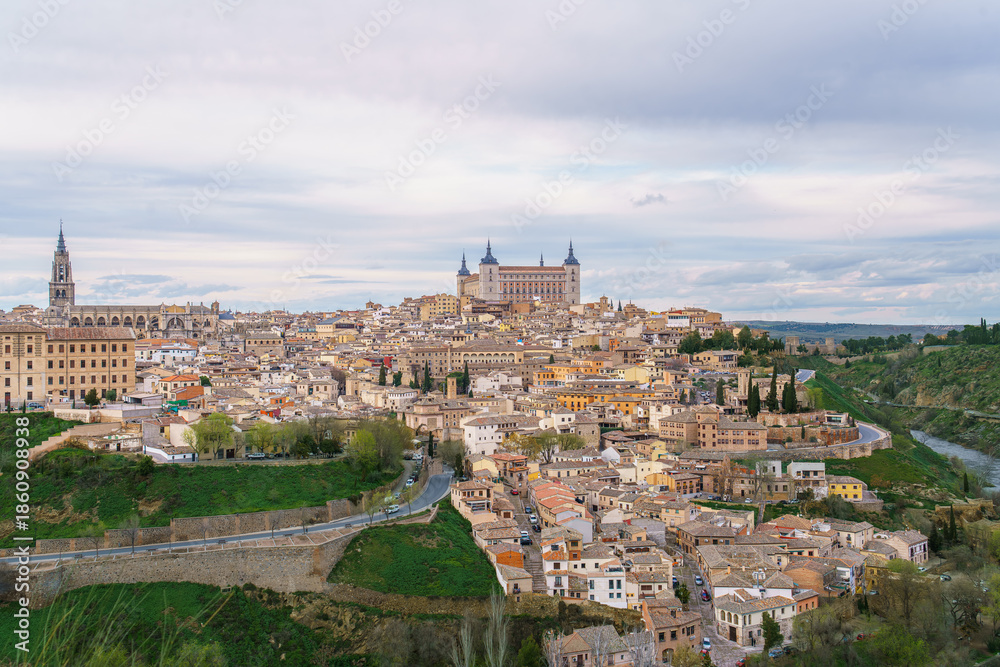 Obraz premium Scenic aerial view of Toledo Spain during spring twilight. The Rio Tajo river winds around the historic city center as a grand natural barrier.