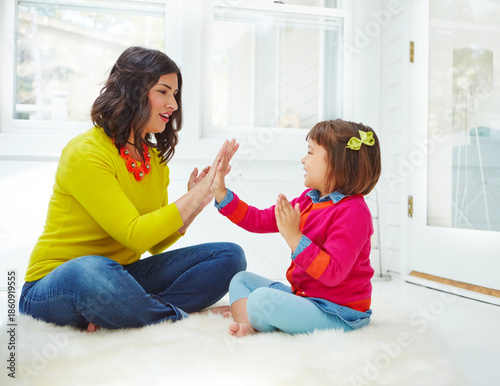 Foto Mom, hand clapping and game in home with bonding, relax and happy for fun with love in morning