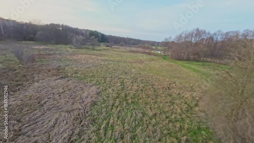 A low and fast drone flight over a river and meadow.