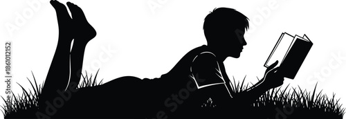 Black silhouette vector illustration of a young boy lying on his stomach in grass reading an open book outdoors