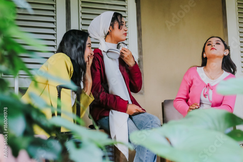 Three stylish young women, sharing stories in a peaceful outdoor ambiance. The scene, filled with genuine warmth, highlights friendship and connection among diverse individuals.