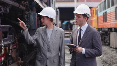 Businesspeople working on tablet and checking train on construction site[
