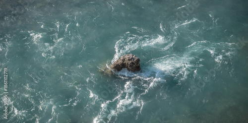 Konstfotografi lonely rock in the middle of a flowing river