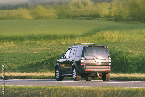 Canvas-taulu Fast SUV driving along quiet country road