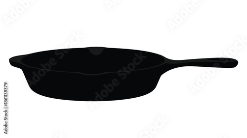 A black cast iron skillet shown in a dark striking silhouette