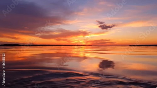 Vibrant Orange and Purple Sunset Sky Reflected in Tranquil Water at Golden Hour, Creating a Serene and Breathtaking Natural Landscape