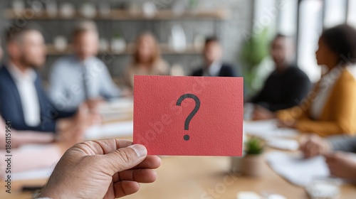 A question mark card is held in front of a board meeting. Uncertainty and ambiguity are the themes. Decisions are unclear, and direction is needed in a conference room.