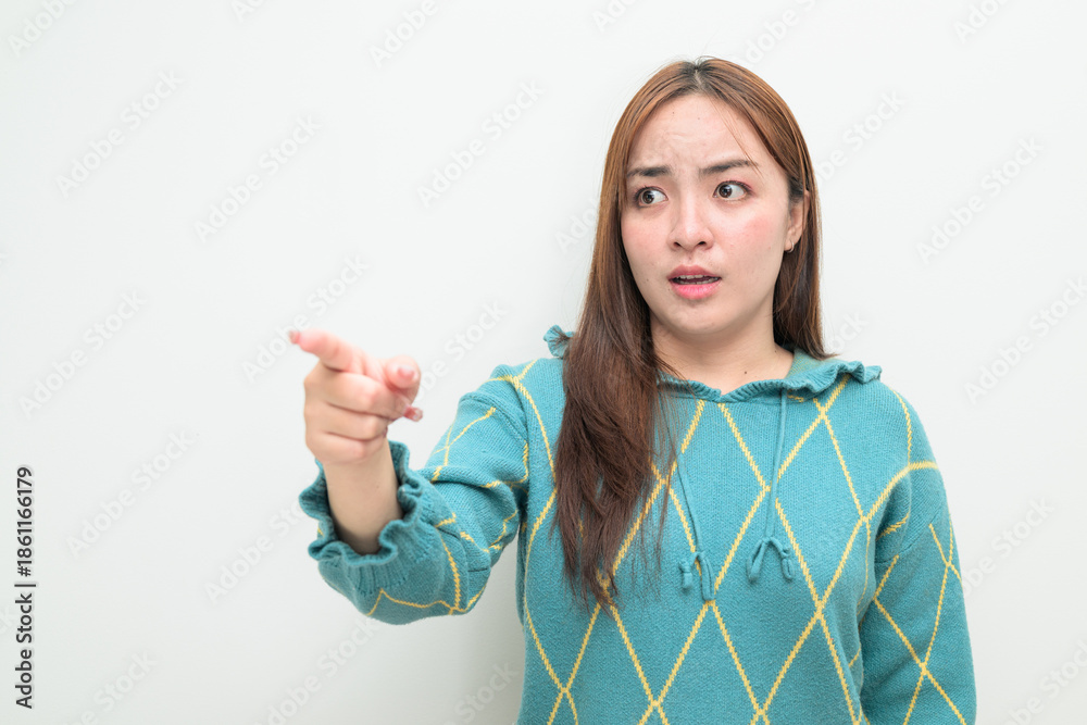 Φωτογραφία Portrait of a young Asian woman against white background pointing finger