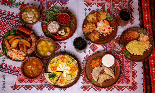 Wallpaper Mural Traditional Ukrainian cuisine set on embroidered tablecloth, borscht, varenyky, potato pancakes, sausages and lard, festive dinner top view Torontodigital.ca