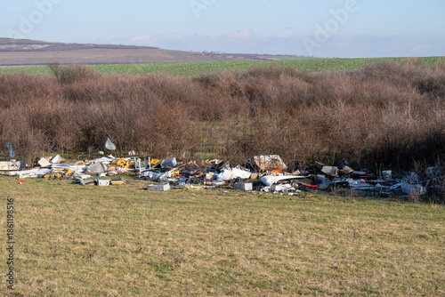 Illegal plastic and industrial waste dumped in a natural field in Romania.