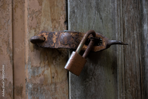 Rusty Padlock On Old Wooden Door