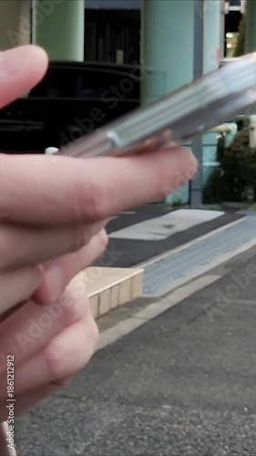 屋外でスマートフォンを持っている女性