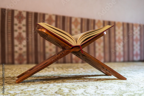 Open Quran on a wooden rehal stand inside a mosque, symbolizing Islamic worship, faith, and spiritual reflection