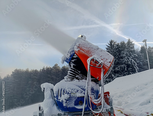 Snow cannon covering a ski slope with artificial snow for winter sports