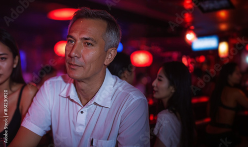 older man in white polo shi...