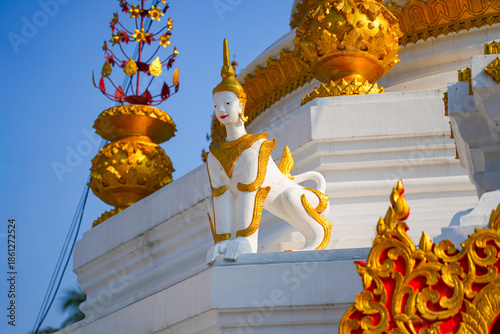 Close-up of a Manussiha (mythical lion-man) on the white chedi of Wat Hua Wiang in Mae Hong Son, Northern Thailand