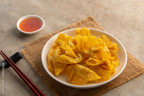 Crispy wonton,Deep Fried Crispy Prawn Wontons sheet on white plate with Sweet Chili Sauce.asian snack food.