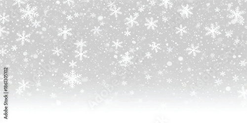White winter snowfall background with different sized snowflakes falling on a gray backdrop.