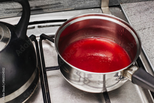 Φωτογραφία Cooking fruit jelly in saucepan on stove