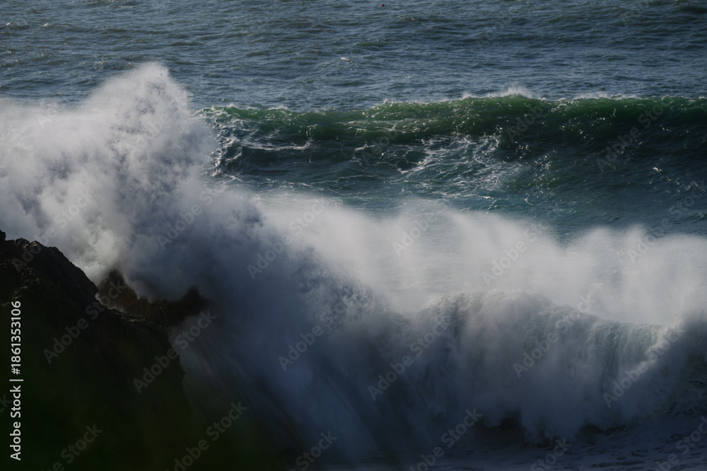 Fototapeta premium Crashing sea waves slam against rugged cliffs in a dramatic ocean seascape