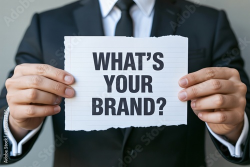 Businessman holding a question about brand strategy, for corporate identity and market positioning, representing professional consulting, Branding awareness concept with 