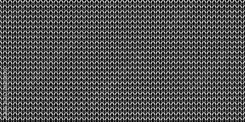 Close up of a dark gray textured knit fabric with a repeating pattern