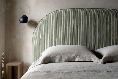 In a bright and airy modern interior, a beautifully designed decorative headboard graces the bed, accompanied by a minimalistic bedside table, creating an inviting atmosphere during the daytime