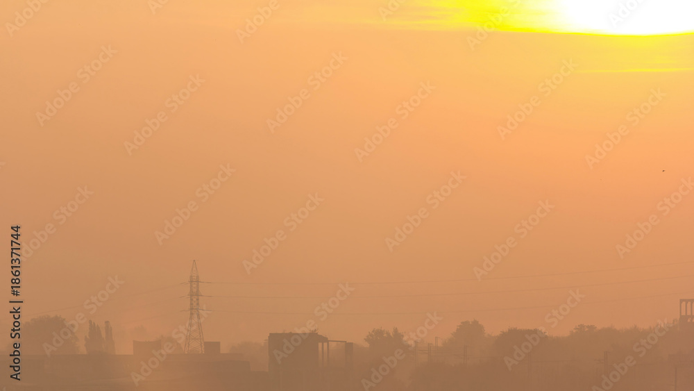 Obraz premium Sunrise at city with high-voltage power transmission line timelapse