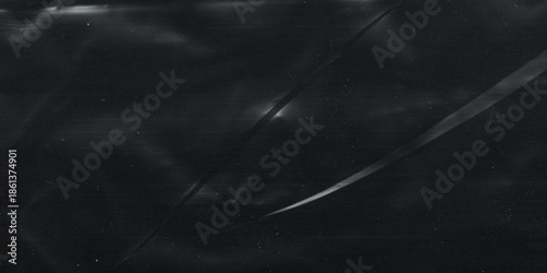Wrinkled plastic wrap texture on a black background. Cellophane package wallpaper