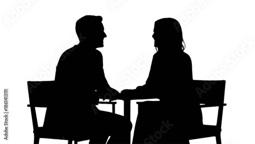 Two people in silhouette sit facing each other, engaged in conversation or meeting.