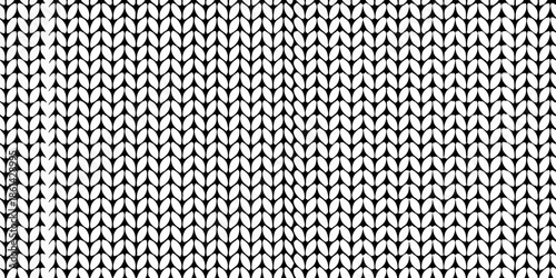 Close up of a black and white knitted fabric texture with a repeating pattern