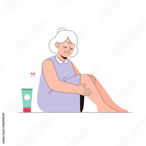 Elderly woman applying lotion to her knee while sitting on the floor  